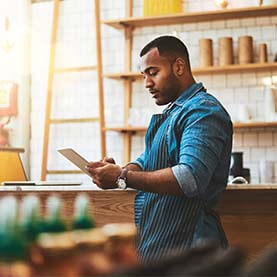 Man working on tablet in cafe