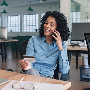 woman on phone holding credit card
